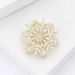 Elegant gold rotating snowflake brooch with sparkling crystals and white pearls for women