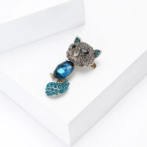 Macro detail of alloy cat brooch featuring deep blue rhinestones and silver metal pin