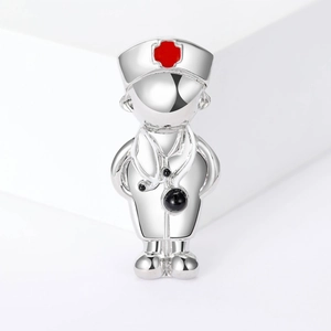 Close-up of silver medical doctor brooch with red cross hat and stethoscope detail