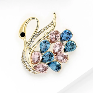 Detail of luxury swan brooch with colorful pear-cut crystals and gold plating