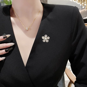 Broche fleur à cinq pétales en zircon doré sur une veste de blazer noire chic