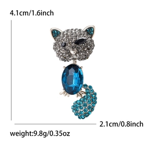 Elegant cat brooch with blue oval crystal and grey rhinestones on a white background