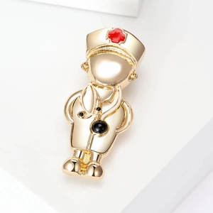 Close-up of golden doctor brooch with stethoscope detail on white geometric stage