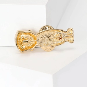 Golden alloy cartoon brooch back view with metallic texture and pin fastener