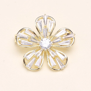 Détail macro d'une broche fleur dorée avec zircons et finition plaquée polie