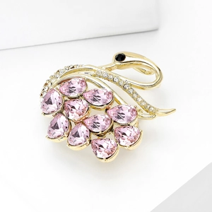 Detailed view of luxury gold swan brooch with pink crystal feathers and zircon inlay