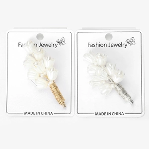 Detailed macro of handmade white lily of the valley brooches with gold and silver wire