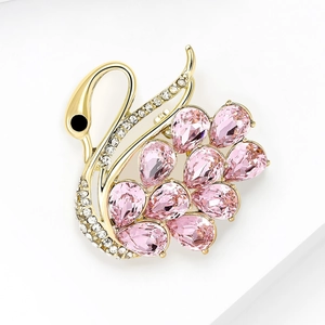 Detail view of gold swan brooch with pink crystal droplets and tiny white zircons