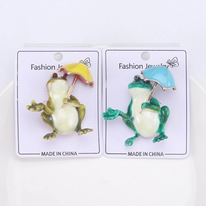 Détail de broches grenouilles mignonnes avec parapluies sur support de bijoux