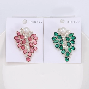 Détail de broches fleur avec pierres roses et émeraudes, perles et cristaux scintillants