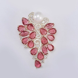 Détail de la broche luxueuse en forme de grappe avec rubis et perle blanche élégante