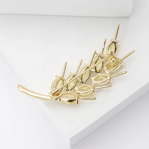 Elegant gold wheat brooch with yellow zircon crystals on minimalist white pedestal