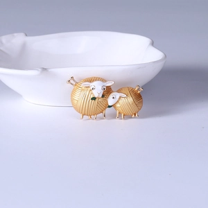 Detailansicht einer Vintage-Schaf-Brosche mit Wollknäuel-Design in Gold und Weißoptik