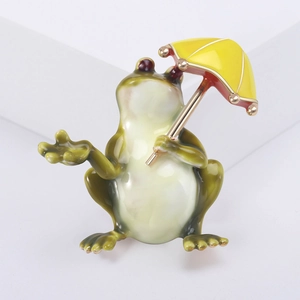 Vue détaillée de la broche grenouille avec parapluie jaune en émail vert et doré