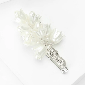 Detail of handmade silver wire wrapped tulip brooch with elegant pearl white petals