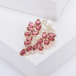 Broche fleur luxueuse avec pierres roses et perle blanche sur support blanc chic
