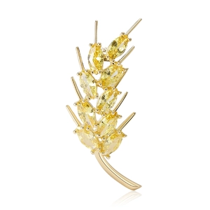 Elegant gold wheat brooch with sparkling yellow marquise-cut zircons on white background