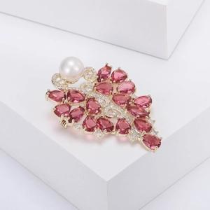 Détail de la broche fleur de luxe avec pierres roses, perle blanche et placage en or