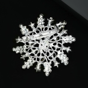 Close-up of snowflake brooch back showing the metal safety pin and hollowed structure