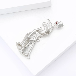Detail view of the silver hand-held rose brooch back showing the pin buckle mechanism