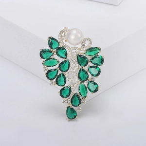 Broche fleur dorée élégante avec grande perle et cristaux verts taillés en poire
