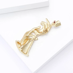 Close-up of the back of gold rose brooch showing safety pin clasp and textured alloy finish