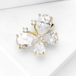 Macro shot of butterfly brooch with pear-cut crystals and gold finish on white pedestal