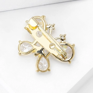 Detail view of mini gold butterfly brooch featuring pear-shaped crystals and secure clasp