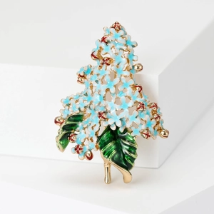 Detail of blue hydrangea enamel brooch with red ladybugs and gold leaves on white base