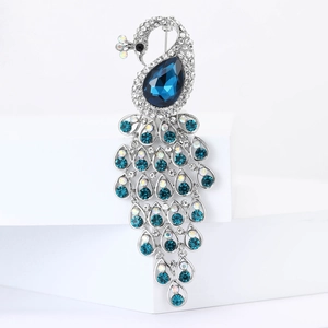 Elegant silver peacock brooch with sparkling crystals and a blue teardrop stone