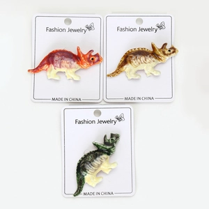 Vue détaillée de trois épingles en émail triceratops colorées sur cartes d'affichage