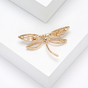 Detailed back view of a golden dragonfly brooch with openwork wings and pin clasp