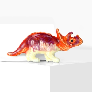 Détail de la broche tricératops avec texture marbrée colorée sur un support blanc