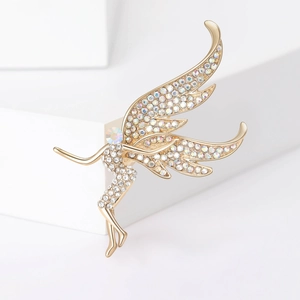 Golden fairy brooch with sparkling white zircons on a minimalist white display