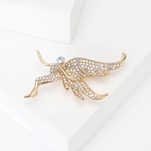 Macro detail of fairy brooch with golden metal wings and sparkling white zircon stones