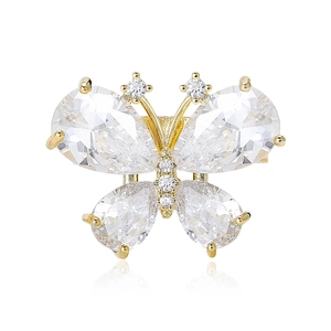 Broche papillon dorée élégante avec cristaux de zircone sur fond blanc avec reflet