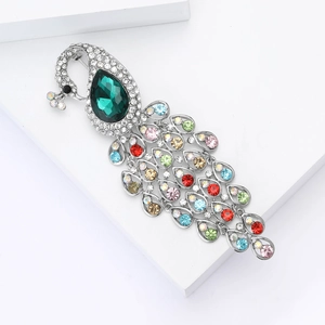 Detail view of colorful peacock brooch with emerald crystal and rhinestone dangling tail