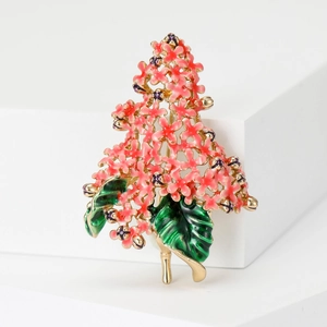 Detail of pink hydrangea brooch with green leaves on minimalist white stand