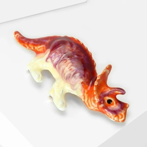 Gros plan sur broche triceratops avec texture marbrée colorée et finition émail