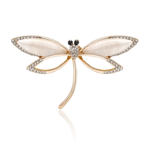 Golden dragonfly brooch with opal wings and sparkling rhinestones on white background