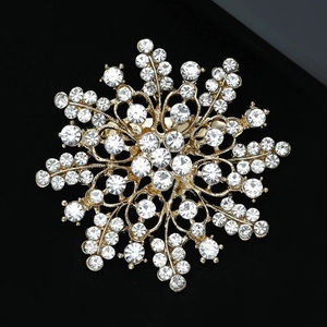 Macro shot of sparkling rhinestone flower brooch with golden finish on black background