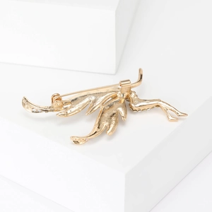 Elegant gold fairy brooch with white zircon wing details on minimalist white cubes
