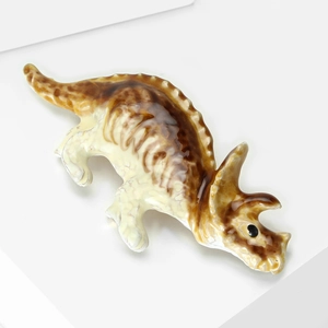 Gros plan détaillé d'une broche dinosaure tricératops marron avec finition émaillée