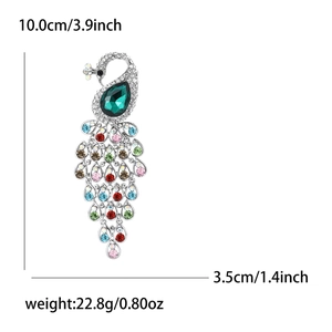 Elegant peacock brooch with vibrant rhinestones and green drop stone in silver finish