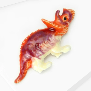 Vue détaillée de la broche tricératops avec une texture de marbre rouge et violet