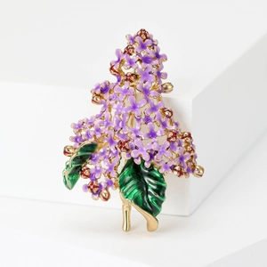Detail of purple lilac brooch featuring enamel petals and golden alloy floral design
