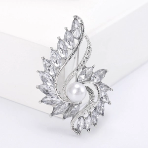 Macro view of a silver-tone alloy brooch with white pearl and marquise crystal petals