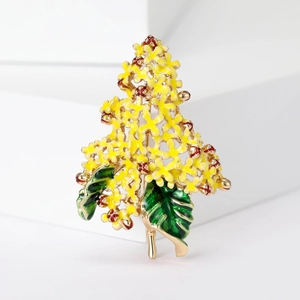 Detail of yellow enamel hydrangea brooch with gold finish and green leaves on white block
