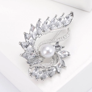 Detail of elegant silver brooch featuring a round white pearl and marquise-cut zircon crystals