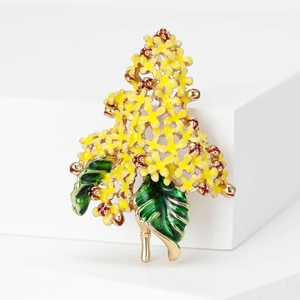 Detailed macro shot of yellow enamel hydrangea brooch with green leaves on gold plating